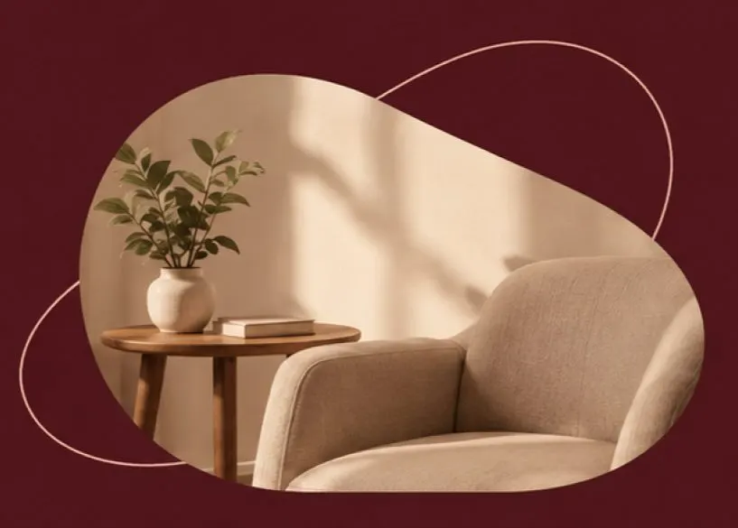 Poltrona do consultório ao lado de uma mesa de apoio com planta e livros.