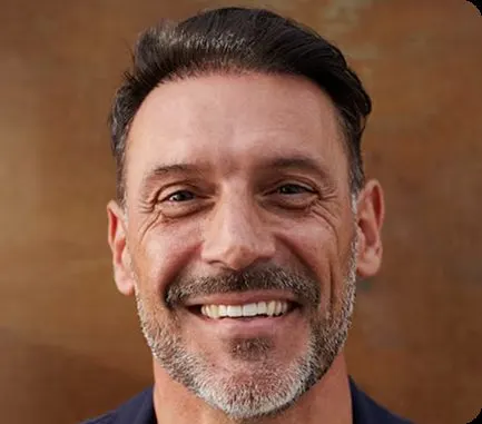 Homem adulto em retrato, sorrindo.