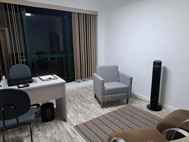 Sala 111, com poltronas e mesa.